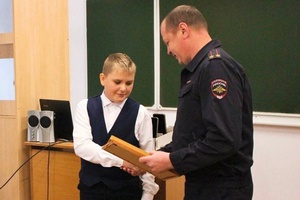 Заместитель начальника Беловской Госавтоинспекции подполковник полиции А. В. Каталкин наградил 14-летнего мальчика, который помог задержать водителя, сбившего ребенка